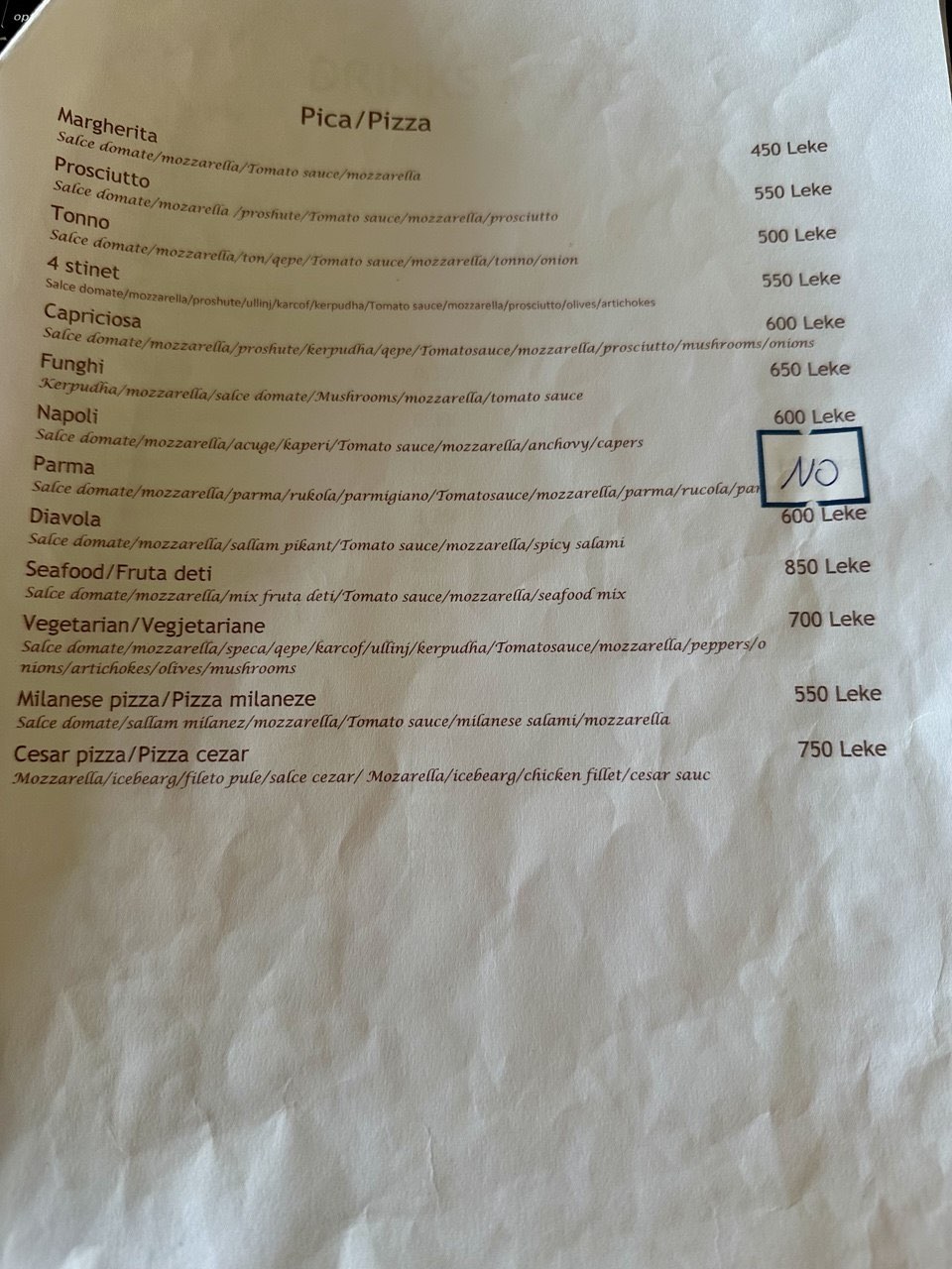 A crumpled A4 menu with a box drawn by hand around one pizza and the word NO written inside it